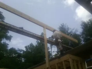 Carpenter setting a ridge beam over a new addition frame — Ice Dam Removal by Roofing Brothers in Rebecca