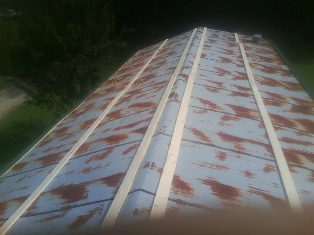 Rusted metal roof panels with new wood purlins before replacement — Storm Damage Roof Repair in Rebecca by Roofing Brothers
