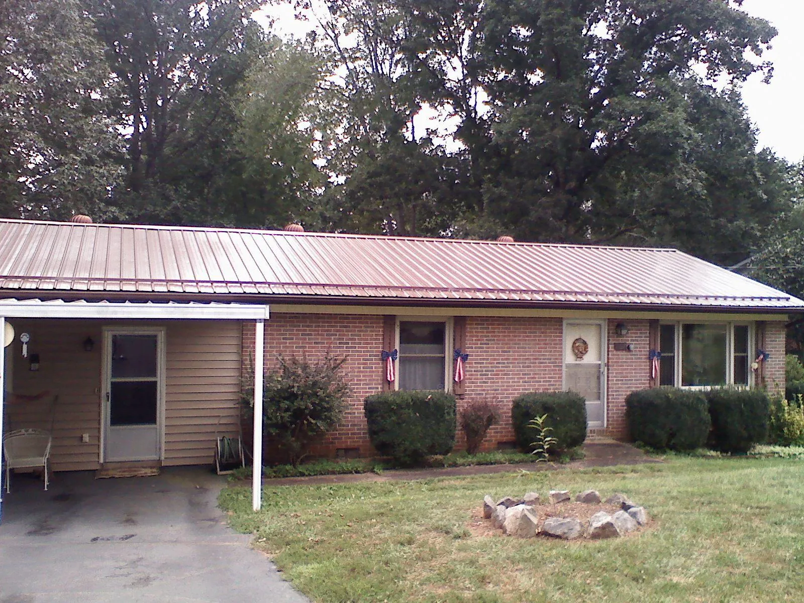 Bronze metal roof and carport on a brick ranch home — Roof Repair work by our crew in Rebecca